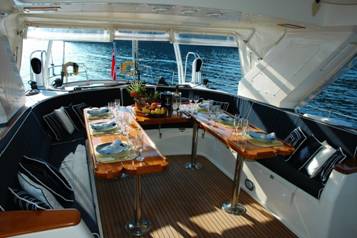 the deck of a ship with brown dining tables