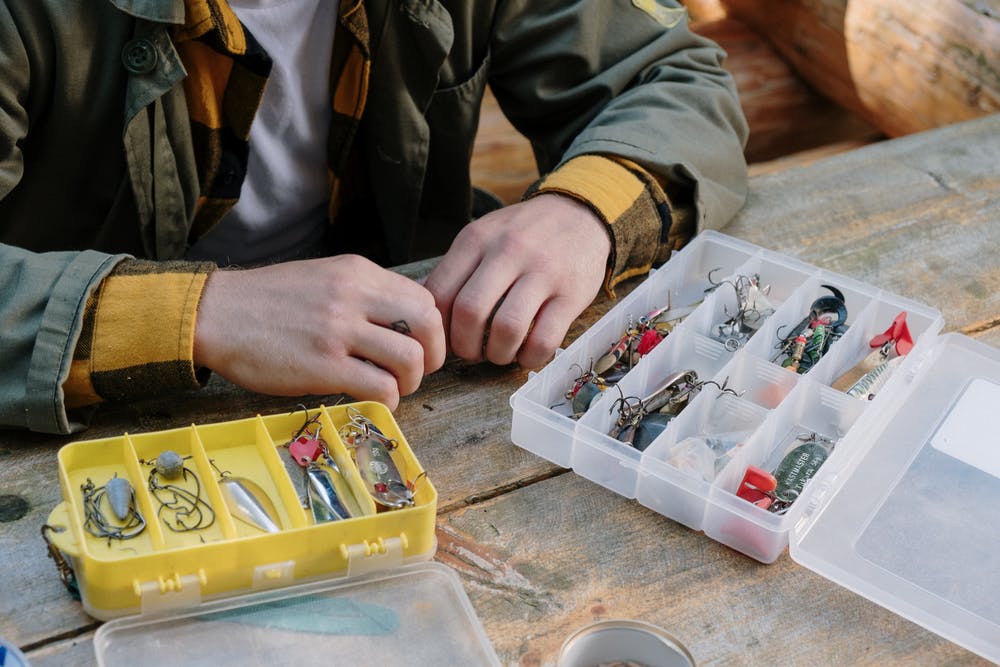  person in gray jacket holding clear plastic container for a fishing trip