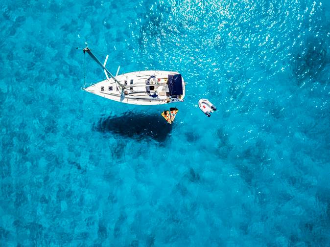 Boat floating on crystal blue water 